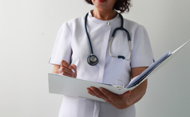 A nurse woman wearing medical coat with a stethoscope write test results in the hospital sheet chart. Serious excited for success medical worker posing on light background