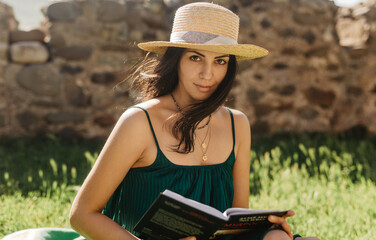 Obraz premium young woman reading a book outdoor
