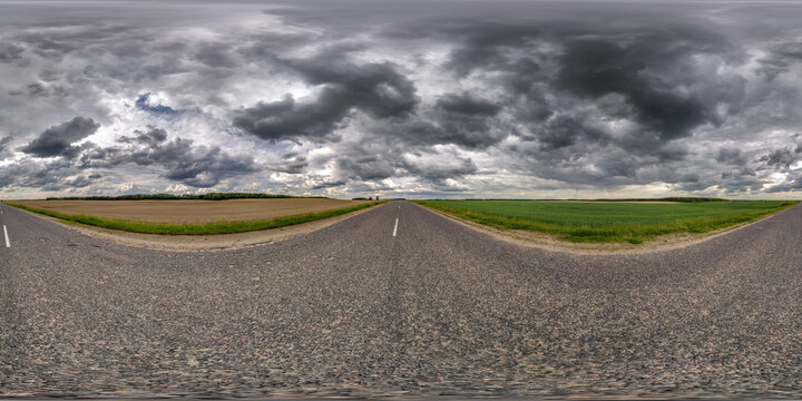 full seamless spherical hdr panorama 360 degrees angle view on old no traffic asphalt road among fields with black rain clouds before storm in equirectangular projection, VR AR virtual reality content