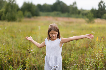 Naklejka na ściany i meble Caucasian girl child runs across the field, happy free childhood