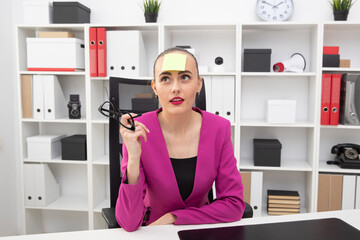 Portrait of a girl in a pink jacket with a sticker on her forehead. The process of creating ideas at work