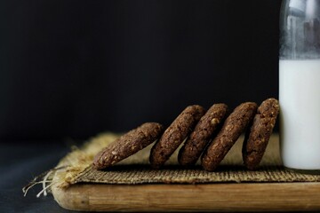 Chocolate and oats Cookies Served with Milk bottle on a wooden board