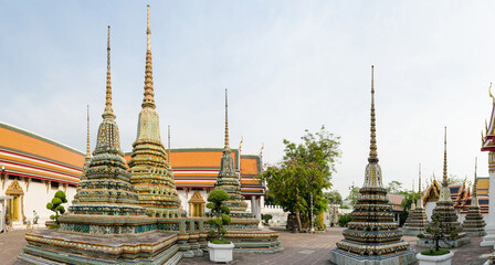 Fototapeta premium Panorama of colorful chedis in Wat Pho Buddhist temple courtyard, Bangkok, Thailand