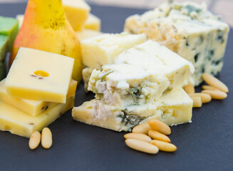 Various types of cheese, pear and pine nuts
