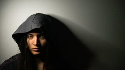 Fototapeta na wymiar A female drug addict in a hood.