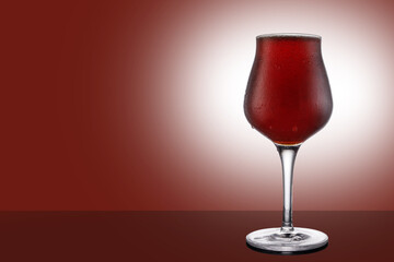 Red ale beer in tulip wineglass isolated on ruby background