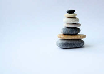 Pyramid of smooth sea stones on a light background. There is free space for text. Concept -Yoga - Wellness- Zen