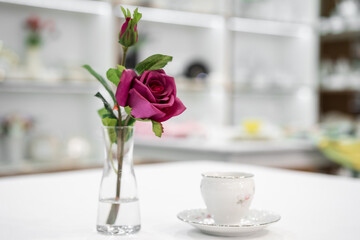 Burgundy rose in a transparent vase on a table in a store