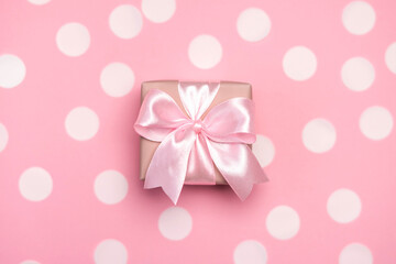 Gift box or present decorated with confetti and ribbon on pink pastel background. Top view with copy space. Flat lay composition for birthday or wedding.