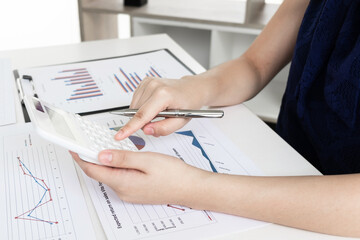 Business women is calculating revenue from graph in the room and work from home.