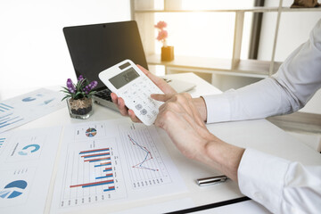 Businessman is calculating revenue from graph in the office room.