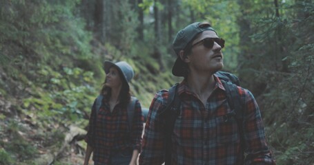 young man and woman hiking in forest