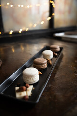 white and chocolate macaroni cookies on a black plate