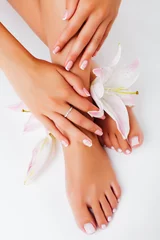 Foto op Aluminium manicure pedicure with flower lily closeup isolated on white background perfect shape hands spa salon © iordani