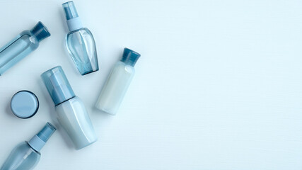 Natural organic SPA cosmetic products set. Flat lay, top view water based skincare beauty products on blue background. Beauty salon banner mockup with hyaluronic acid collagen cosmetics packages