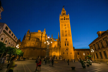 Naklejka premium Night view of the Plaza Virgen de los Reyes with the Giralda and the cathedral of Seville, Spain.