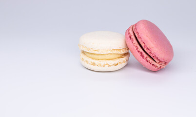 Obraz na płótnie Canvas Sweet white and pink french macaroon or macaron dessert isolated on white background. White and pink cookies