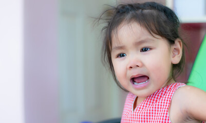 An Asian kindergarten little girl is crying.
