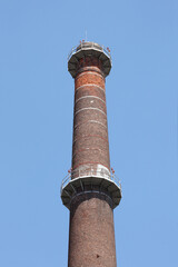  tall industrial chimney on a blue sky with copy space for your text