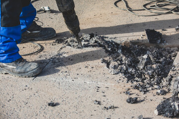 Process of road repairing works with jackhammer, builder worker with  pneumatic hammer and drill...