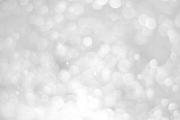 White glitter vintage lights background. White bokeh on black background.