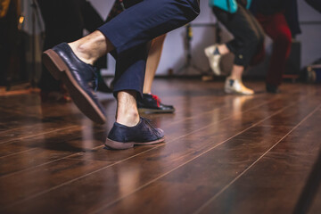 Dancing shoes of young couple dance retro jazz swing dances on a ballroom club wooden floor, close up view of shoes, female and male, dance lessons