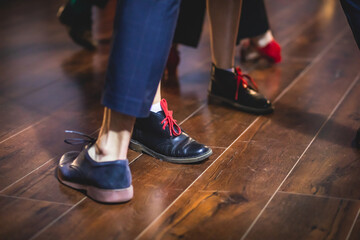 Dancing shoes of young couple dance retro jazz swing dances on a ballroom club wooden floor, close up view of shoes, female and male, dance lessons