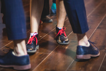 Dancing shoes of young couple dance retro jazz swing dances on a ballroom club wooden floor, close up view of shoes, female and male, dance lessons