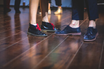 Fototapeta premium Dancing shoes of young couple dance retro jazz swing dances on a ballroom club wooden floor, close up view of shoes, female and male, dance lessons