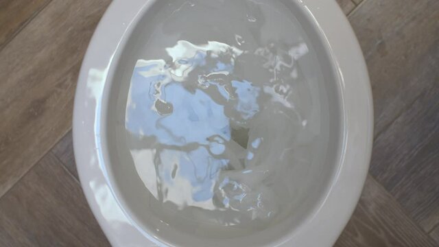 Close up clogging of the toilet. The water flows into the toilet but does not go away. Toilet paper causes clogging. Plumbing in need of repair. Top view