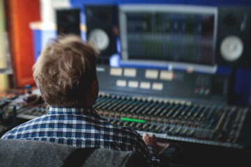 Sound editor engineer working at studio with mixing panel, mixing music and sound, stage sound...