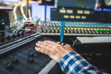 Fototapeta premium Sound editor engineer working at studio with mixing panel, mixing music and sound, stage sound mixer, boutique recording studio, working during concert performance recording, broadcasting studio