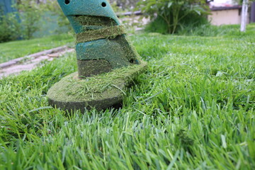 Lawn mower trimer mows grass. Green lawn. Neat work. 