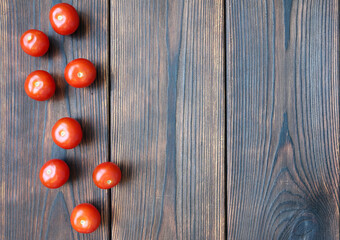 Naklejka na ściany i meble Red cherry tomatos on dark wooden boards