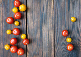 Red and yellow cherry tomatos on dark wooden boards