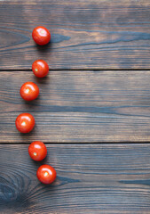 Fototapeta na wymiar Red cherry tomatos on dark wooden boards