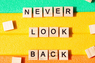 Words written on wooden blocks. Colorful background. Never look back. Motivational message. Words and phrases . Concept 