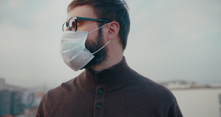 Pandemic N1H1 coronavirus protection. Young european tourist man wearing protective mask on traffic street background.Concept of healtcareh and safety life, N1H1 coronavirus,world virus protection