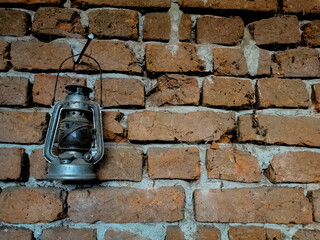 Old petrol lamp on a red brick wall