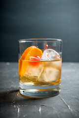 Old fashioned beverage with orange slices on rustic background. Selective focus. Shallow depth of field.