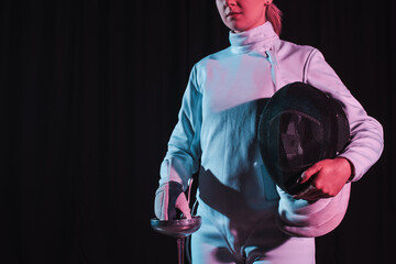 Cropped view of fencer holding rapier and fencing mask isolated on black