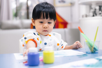 Asian toddler girl is painting water color. toddler activity at home. - 353655382