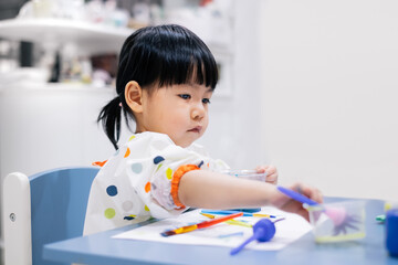 Asian toddler girl is painting water color. toddler activity at home. - 353655517