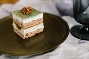 square cake on a gold plate with flowers on the background