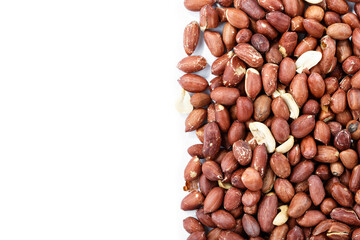 peeled peanuts sprinkled on a white background. Peanut texture is clearly visible. place for text.