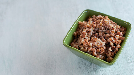 Cooked buckwheat porridge. Porridge in a bowl on the table. Copy space