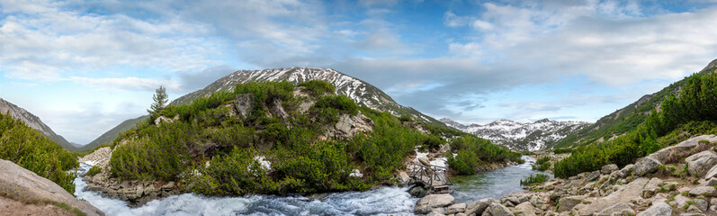 Beautiful panorama landscape of the Pirin mountain covered with snow at spring time in Bulgaria. Panoramic view