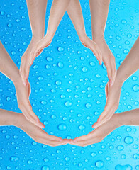 Men forming water drop with their hands on blue background. Ecology protection