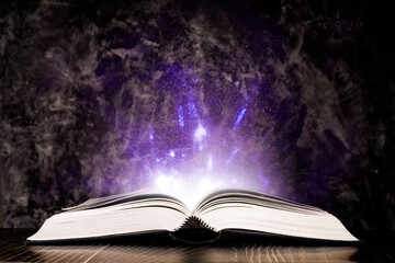 Magic book with light on black background