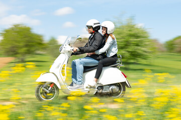 man and girl riding an Italian motor scooter in the countryside